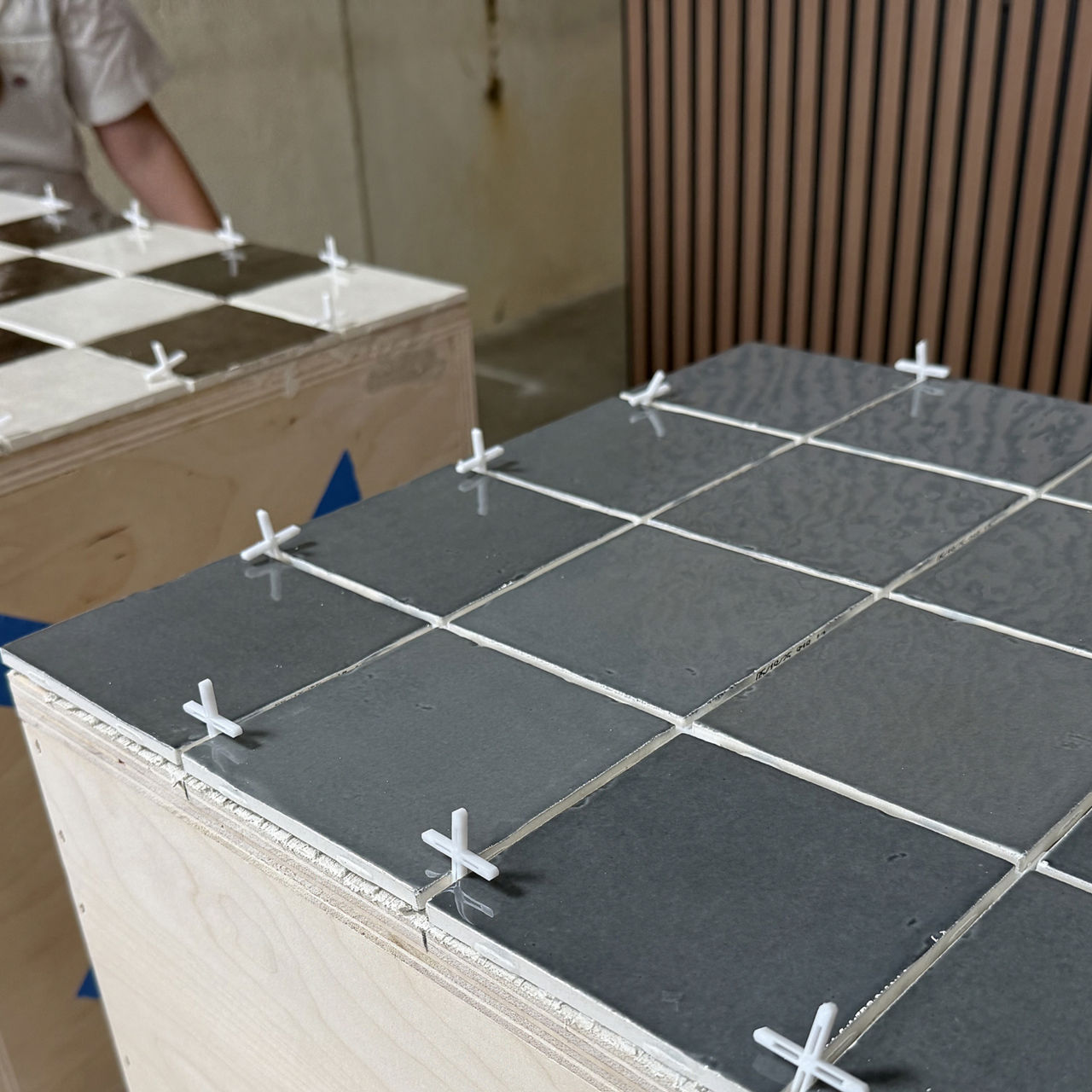 Table with gray square tile and spacers used between each tile.