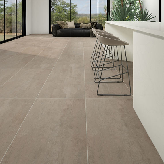 Living area with white bar, dark beige rectangle concrete look floor, three gray bar chairs, and a black couch.