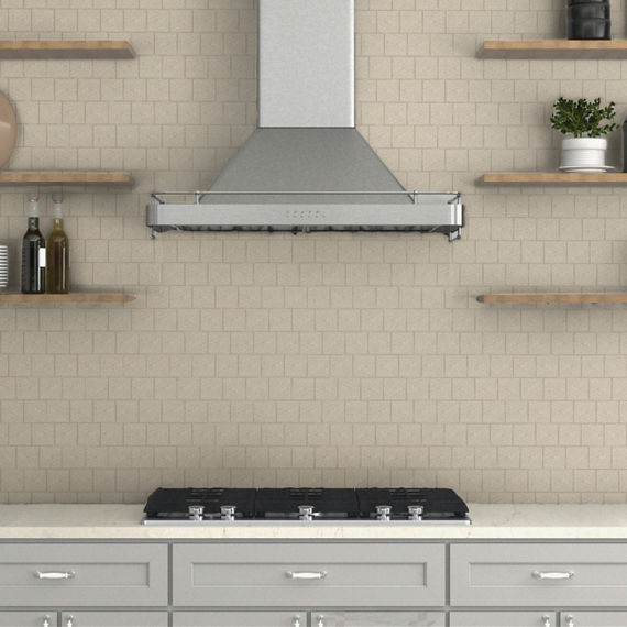 Close up of kitchen with wood floating shelves, gray cabinets, white countertop, and white square mosaic backsplash with brown gout.