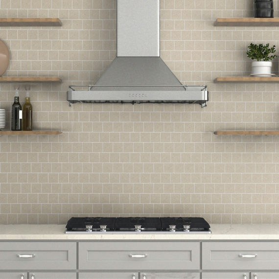 Close up of kitchen with wood floating shelves, gray cabinets, white countertop, and white square mosaic backsplash with white gout.