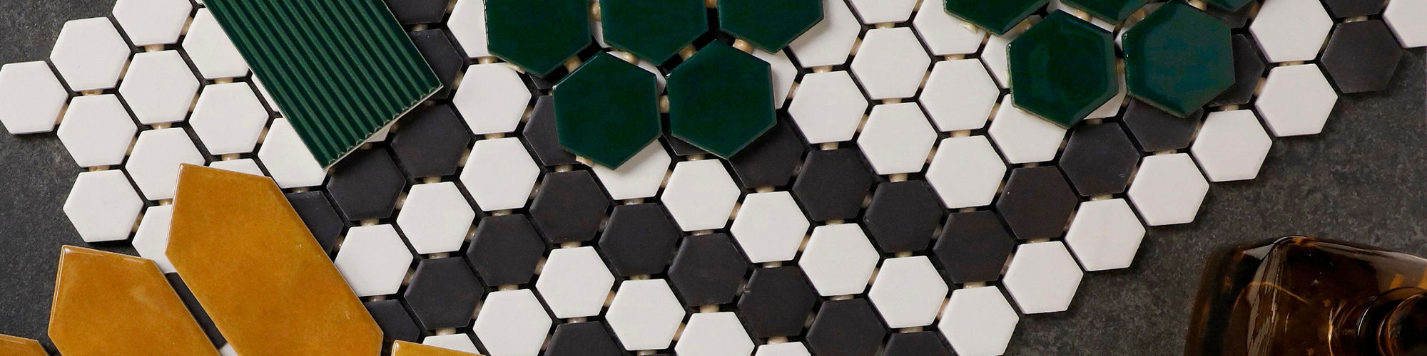 Tile flatlay with mustard yellow hexagon tiles, white round mosaic tiles, and green rectangular tiles arranged in a bold pattern.