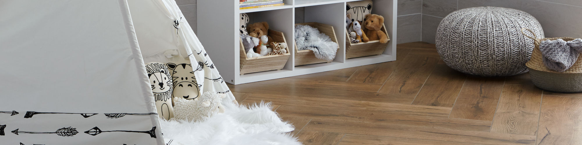 Kids room with tent, bookshelf, and wood like tile on the floor.