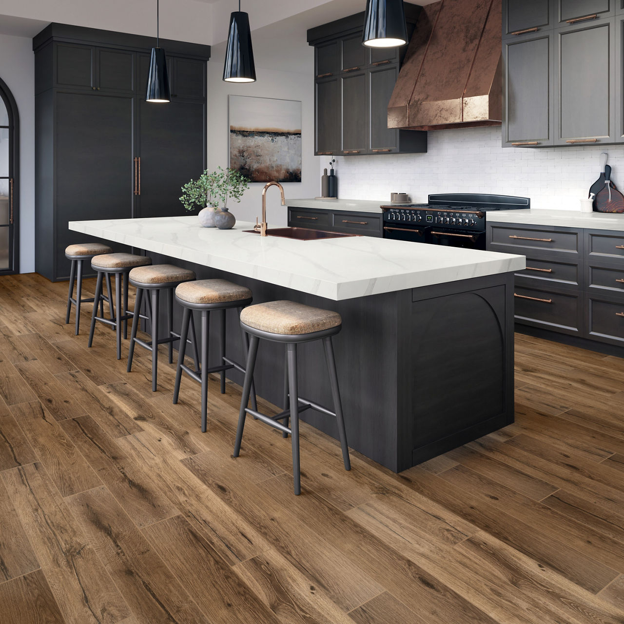Kitchen with black cabinets, brown wood plank floor tile, white marble look countertop, and beige bar stools at center island