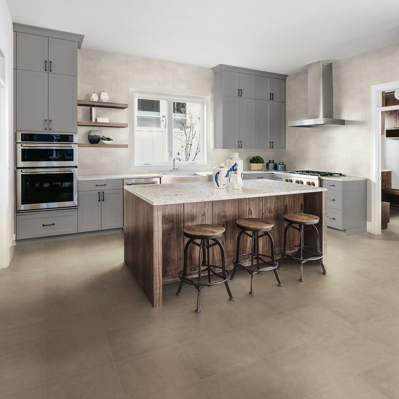 Kitchen with gray cabinets, wood center island, white walls, white quartz countertops, and dark beige floor tile.