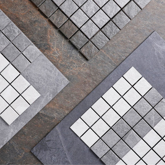 Flatlay with gray stone look tile, and straight joint mosaic tile in gray and white.