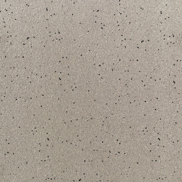 A closeup view of a light gray stone or composite surface featuring small, scattered black specks. The texture appears smooth with a matte finish, commonly used for countertops, flooring, or wall panels. The image is evenly lit, highlighting the subt