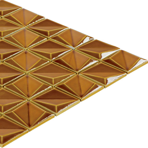 A sheet of metallic golden tiles is arranged in a repeating geometric pattern. Each tile forms a raised pyramid shape, creating a three-dimensional surface. The tiles are shown on a white background, emphasizing their reflective gold finish and facet