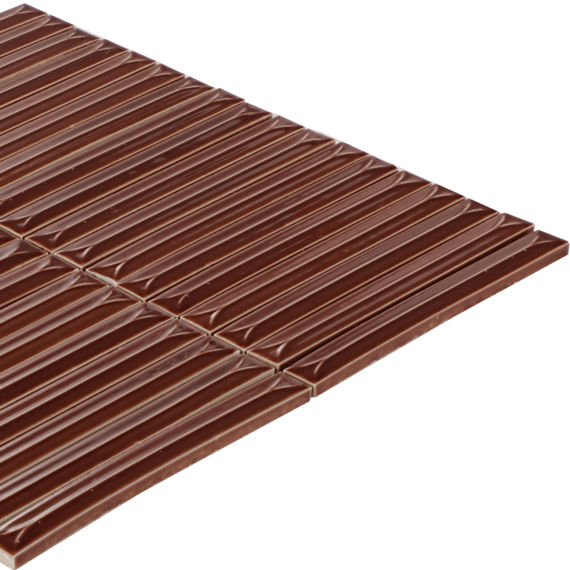 A large milk chocolate bar with a distinctive geometric pattern is shown isolated on a white background. The bar is divided into many long, narrow ridged segments, creating a modern, architectural look. The smooth, glossy surface highlights the rich 