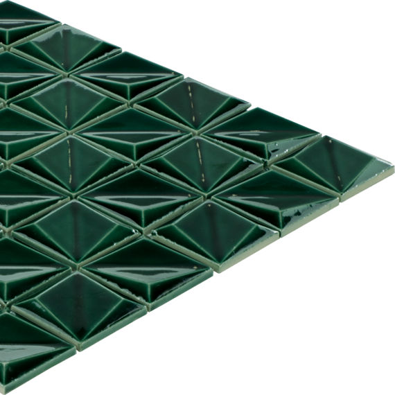 A sheet of dark green tiles is arranged in a repeating geometric pattern. Each tile is shaped like a raised pyramid, creating a three-dimensional surface. The glossy finish reflects light, emphasizing the angular facets and depth. The tile sheet is i