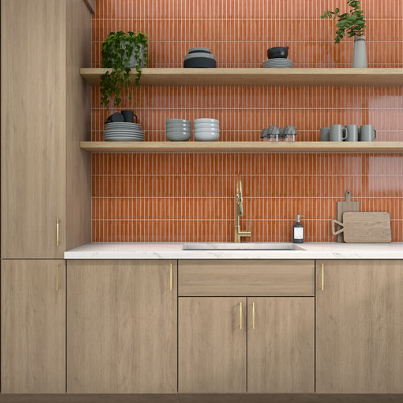 Kitchen with orange rectangle mosaic on backsplash, wood cabinets, white marble look countertop, and wooden shelves with dishes and plants.