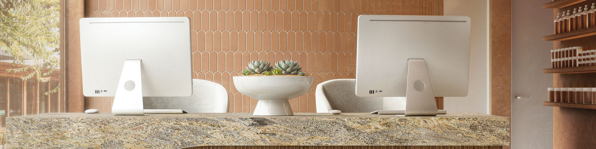 Front desk with orange fishscale mosaic tile on back wall, rectangle mosaic on counter wall, and a beige granite countertop.