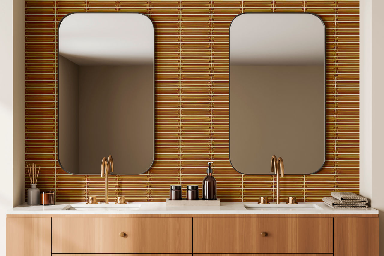 Bathroom with twin sinks, orange rectangle mosaic on the back wall, wood cabinets, and gold accents.