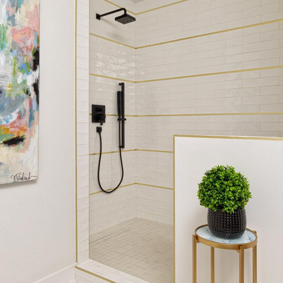 Shower with white subway tile on walls, white penny round tile on floor, white square hexagon mosaic on shower floors, and black accents.