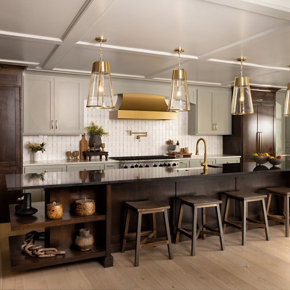 Kitchen with dark wood cabinets, black marble countertop on the island and perimeter countertops, and a white mosaic on the backsplash. 