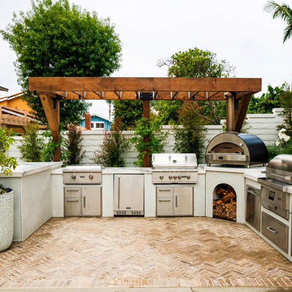 Outdoor kitchen with white marble look porcelain counter, wooden chairs, and a silver grill.