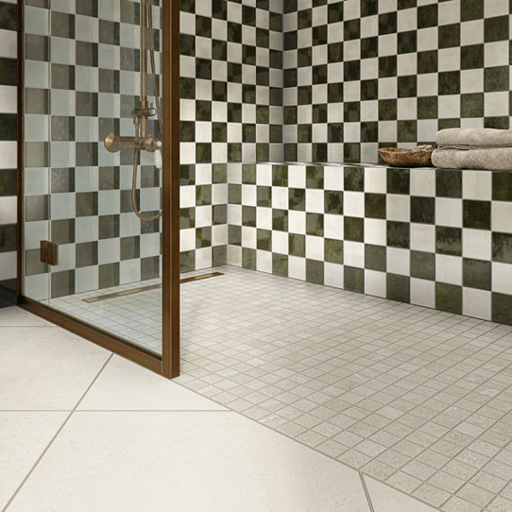 A contemporary bathroom features a walk-in shower with a glass door and striking black-and-white checkered tile walls.