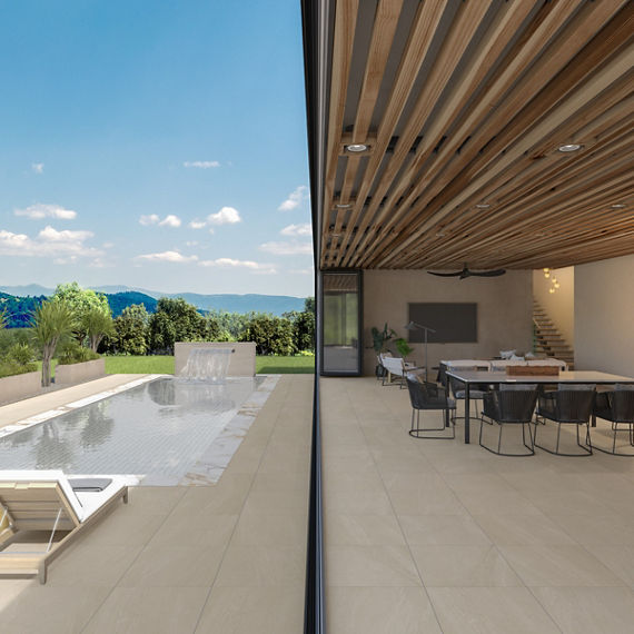 Dining room and backyard separated by floor to ceiling window, beige concrete look rectangle tile on floor, large pool with waterfall, and a mountain view.