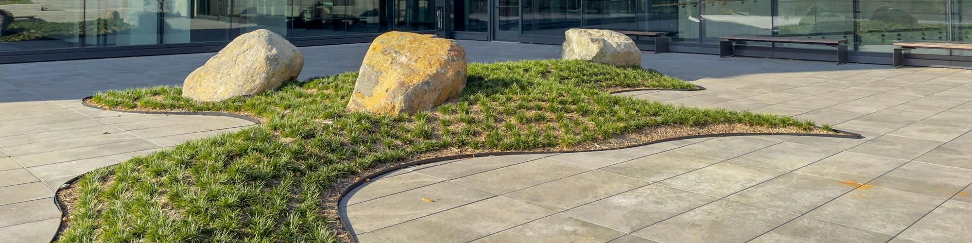 Exterior view of Charlotte Corporate Campus with light gray porcelain pavers on ground.