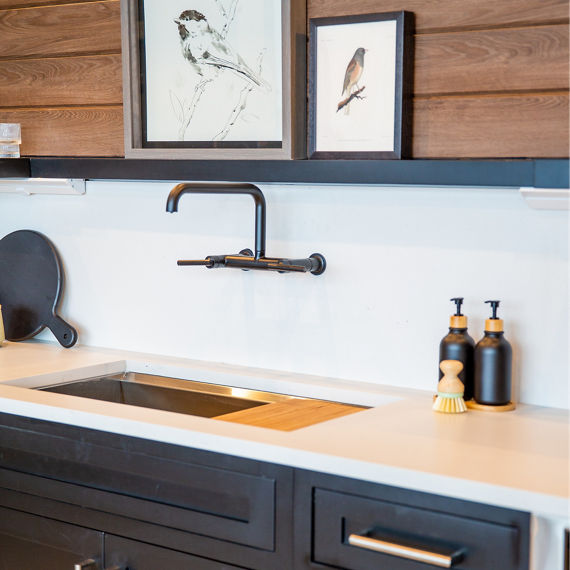 Chip Wades residential renovation, Pinhoti Peak, ADU kitchen with white quartz countertop and backsplash, natural wood shiplap, and black floating shelf.