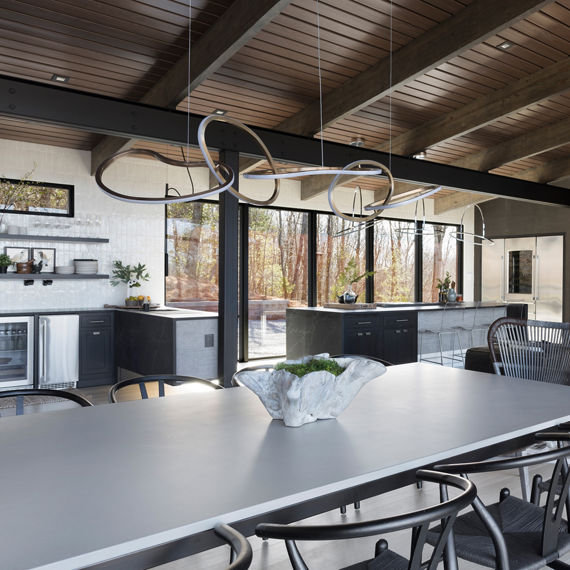 Chip Wades residential renovation, Pinhoti Peak, open kitchen, dining room, living room with black quartz countertops, white glossy wall tile, and floor to ceiling windows.