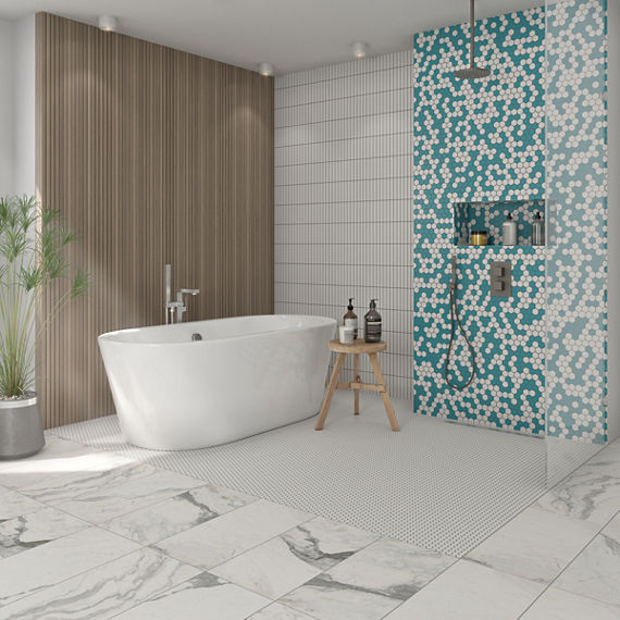 Bathroom with white marble tile floor, soaker tub in front of wood look tile wall, shower with white and teal hexagon mosaic tile shower wall and white floor tile.