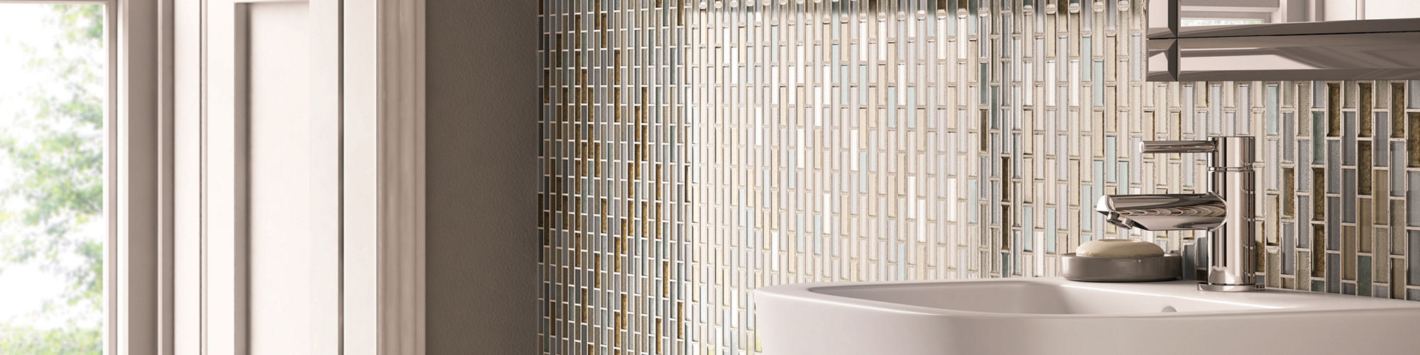 Small bathroom with feature wall behind the sink and mirror. One by two inch glass tiles in varying colors in gray, brown, and tan.