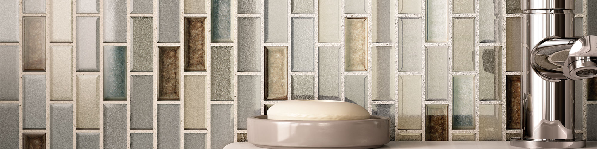 Small bathroom with feature wall behind the sink and mirror. One by two inch glass tiles in varying colors in gray, brown, and tan.