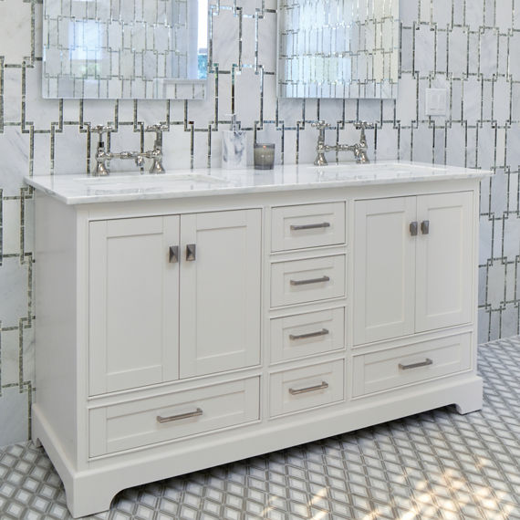 Bathroom with his and hers sinks, and a white marble look mosaic, white countertop, and silver accents.