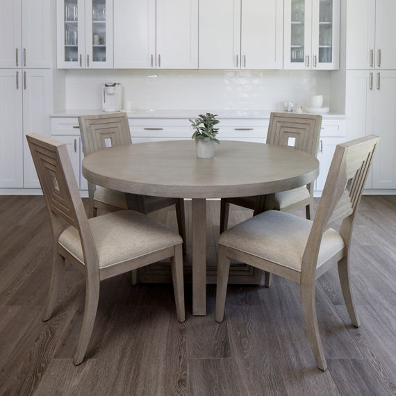 Kitchen with white subway tile on backsplash, white cabinets, beige kitchen table, and wooden floors.