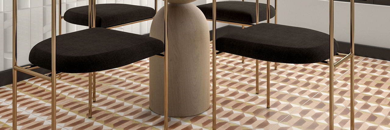 Closeup of dining room floor with rust, peach, and white decorative tile, and a wood table with four chairs.