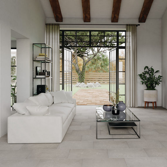 Living room with white rectangle stone look floor tile, two white couch, white walls, and a glass coffee table.