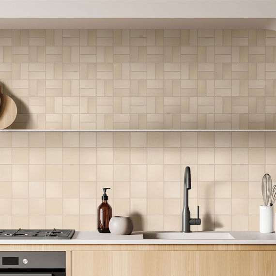 Kitchen with square beige tile on backsplash, beige rectangle tile on top half of wall in basketweave mosaic, wood cabinets, and a white countertop.
