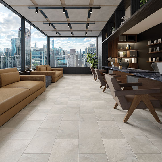 Loung with light gray stone look floor tile, orange couches, and brown chairs.