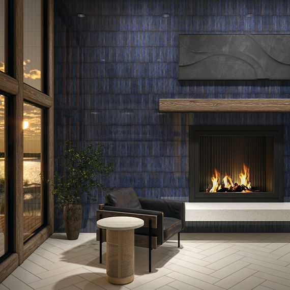 Living room with navy blue metallic look subway tile on back wall, white rectangle floor tile in herringbone pattern, black sitting chair, and a lit fireplace.
