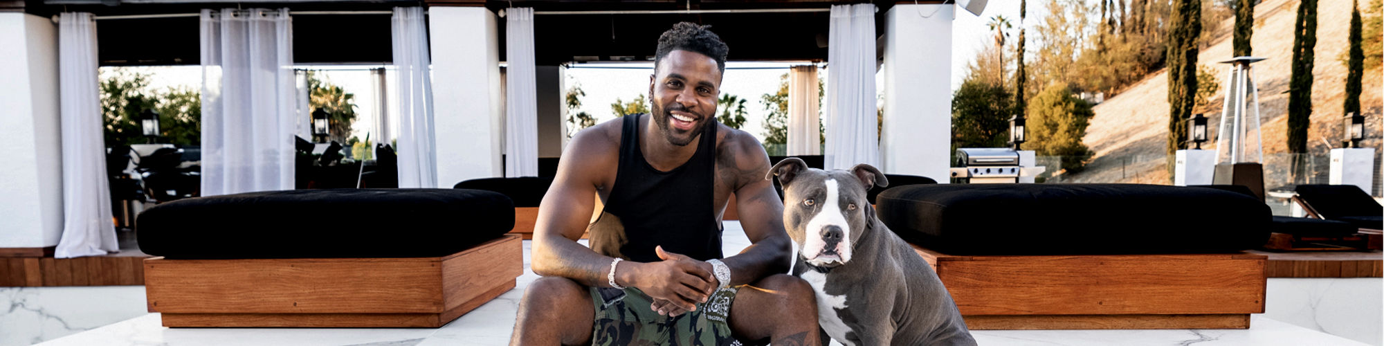 Jason Derulo and his dog, Ice, sitting together in Jasons backyard.