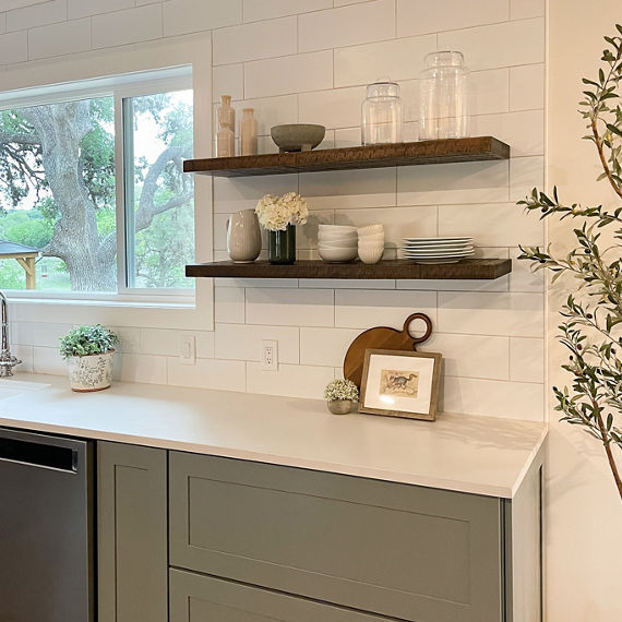 Kitchen with white subway tile on backsplash, white concrete look quartz countertops, and wood accents.