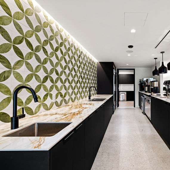 Lunch bar with white marble look porcelain slab counter on bar, white floor, and black coffee station.
