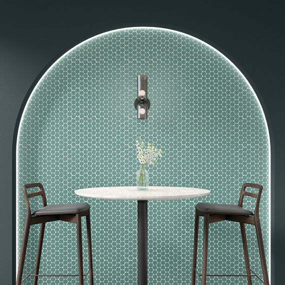Cafe with blue hexagon mosaic tile in arch, blue walls, tall white round table, and two tall chairs.