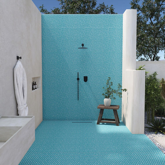 Outdoor shower with two white side walls, and a blue penny round mosaic on shower wall and shower floor.