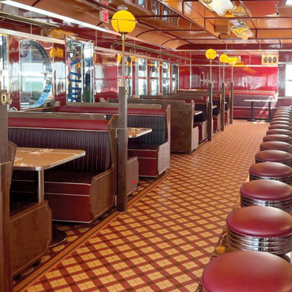 Diner with red and orange mosaic floor tile, red chairs, and wooden booths