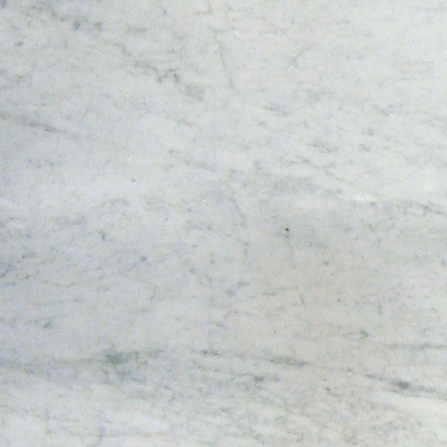 Close-up view of a light gray marble surface with subtle veining. The stone texture shows natural variations in tone and fine, organic lines. The image is evenly lit, creating a neutral and minimal background. It can be used as a backdrop or surface 