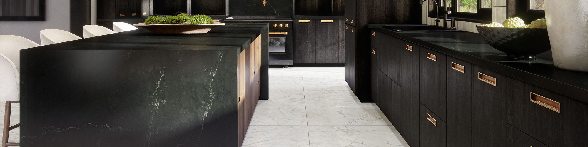 Kitchen with black marble look slab countertops, black cabinets, and white marble look floor tile.