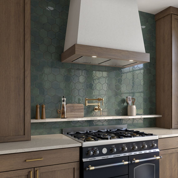 Kitchen with green hexagon backsplash, wood cabinets, white countertop, and white shelf with kitchen utensils.