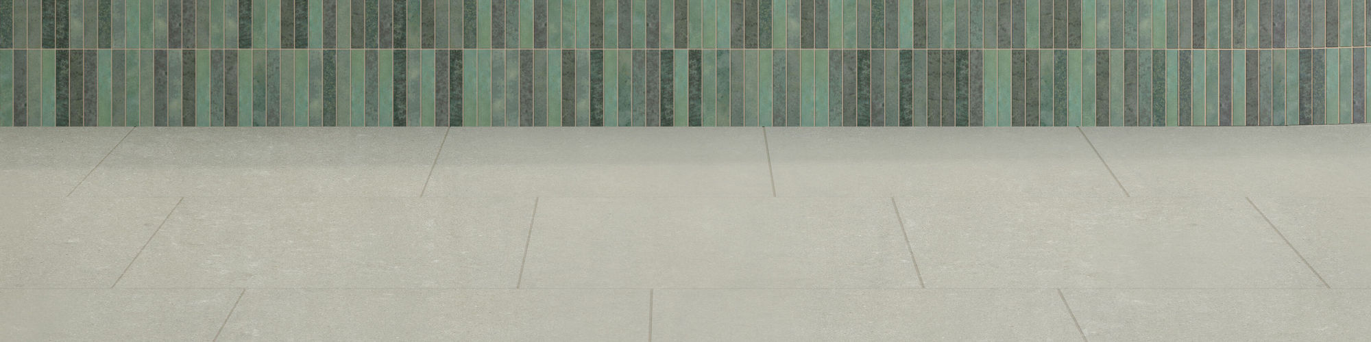 Coffee and pastry shop with white marble look quartz countertop, teal mosaic tile counter base, off white terrazzo look wall tile and gray floor tile.