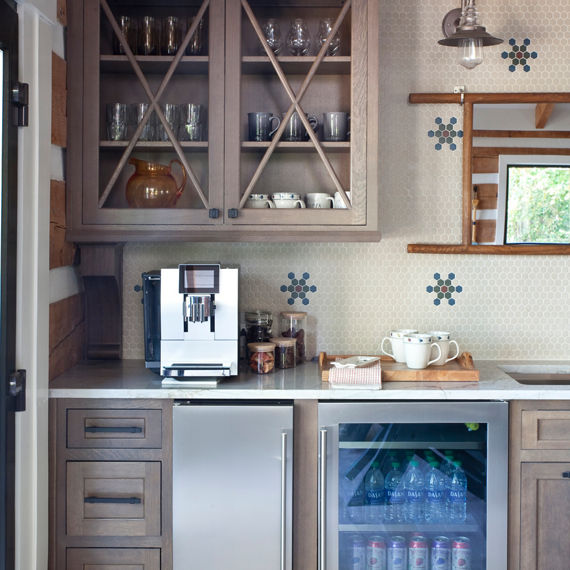 Kitchen backsplash with beige hexagon mosaic tile, blue mosaic tile, green mosaic tile, on in a flower pattern, white quartz countertop, and beige cabinets.