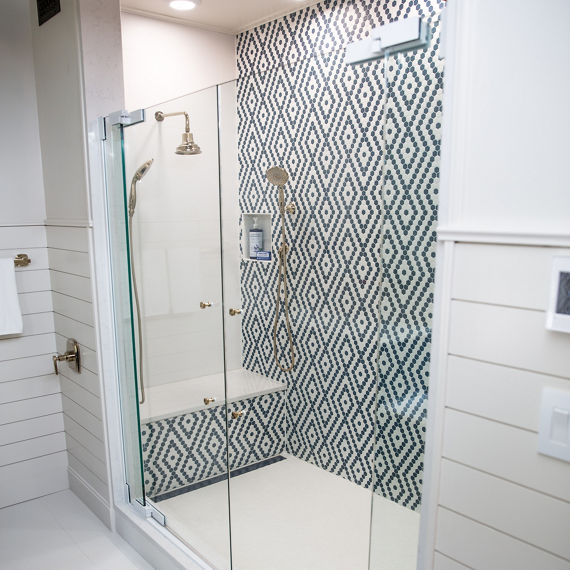 Stand up shower with diamond pattern on walls using white hexagon mosaic tile and blue hexagon mosaic tile.