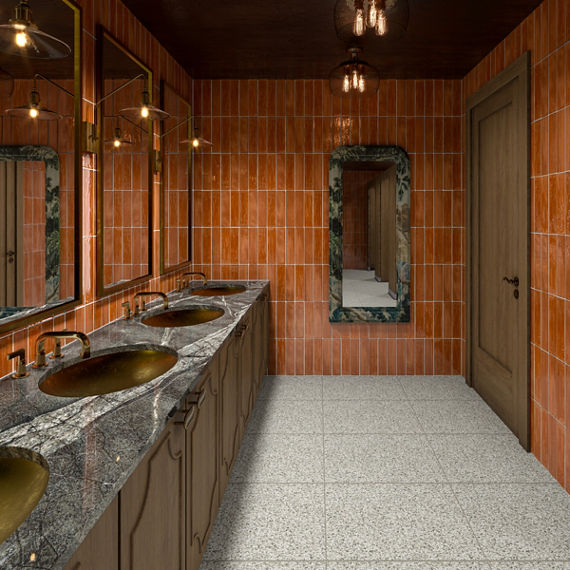 Bathroom with orange subway tile on walls, gray granite countertop, wood cabinets, and white terrazzo look square floor tile.