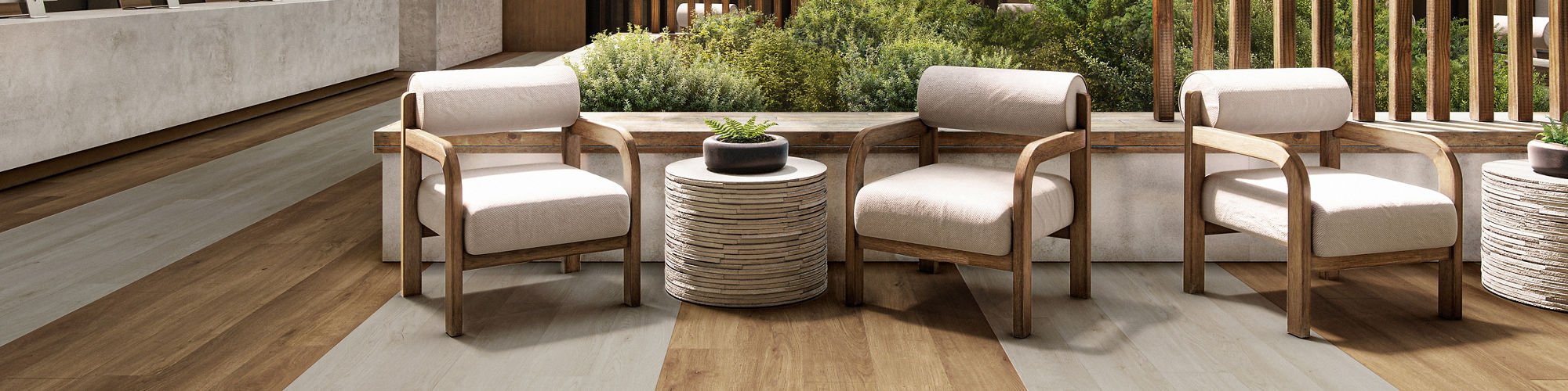 A spacious, contemporary hotel lobby features a central seating area with cushioned chairs and a round table.