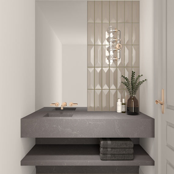 Bathroom with beige subway tile with wave pattern on back wall, gray counter, white walls, and gold accents.