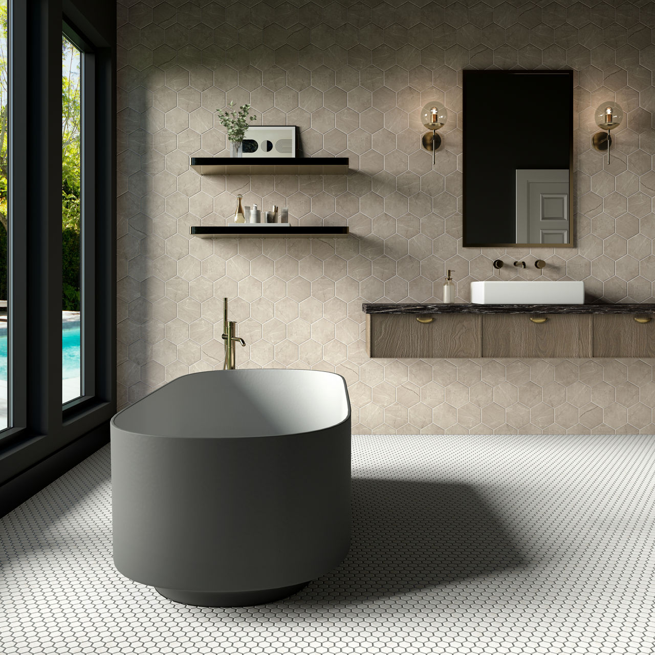 A contemporary bathroom features a sleek freestanding bathtub in the foreground. The space includes a wall-mounted vanity with a rectangular sink, brass faucet, and matching hardware. Floating shelves hold decorative items against a hexagonal tile ac